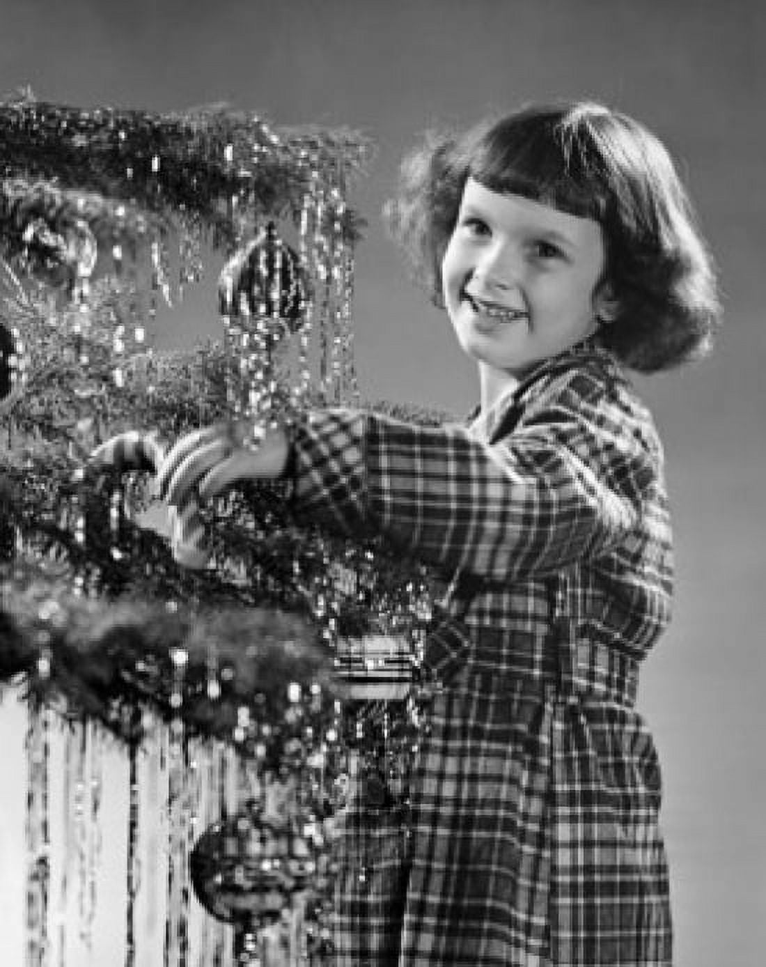 Girl standing near a Christmas tree and smiling Canvas Art - (18 x 24)