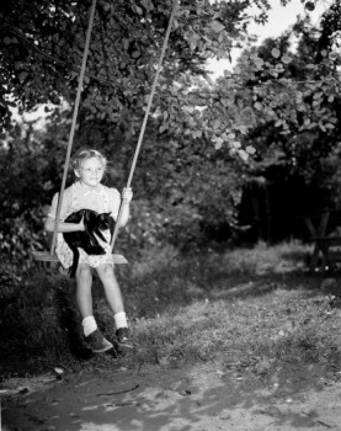 Girl swinging and holding black cat Canvas Art - (18 x 24)