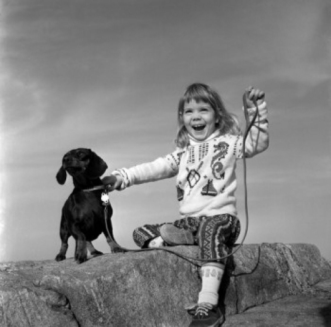Girl with dog sitting on rock Canvas Art - (24 x 36)