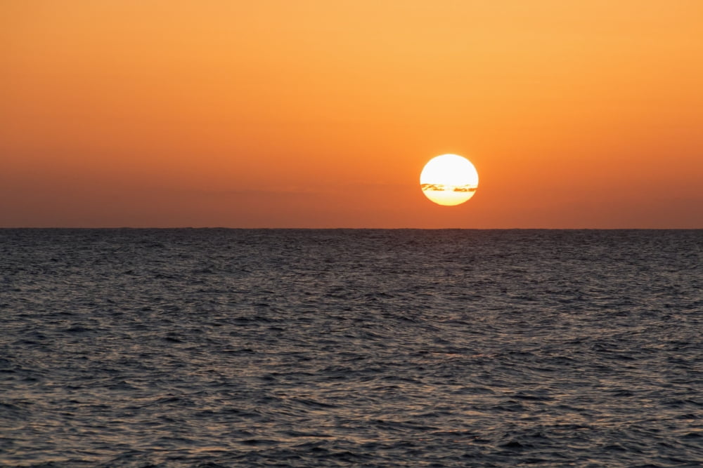 Glowing sun over the ocean and horizon at sunset Paphos Cyprus Canvas Art - John Short Design Pics (19 x 12)