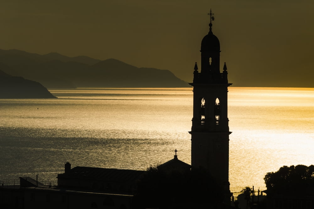 Golden sunlight reflected on water at dusk with tower of church San Lorenzo della Costa Liguria Italy Canvas Art - Yves Marcoux Design Pics (38 x 24)