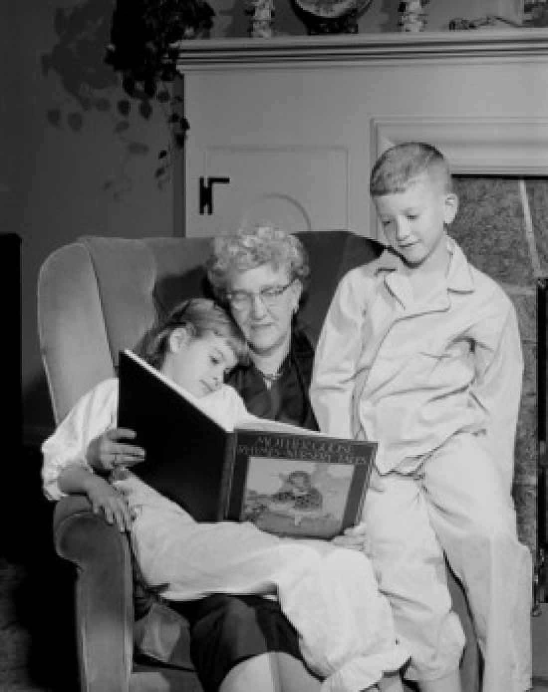 Grandchildren reading with grandmother in living room Canvas Art - (24 x 36)
