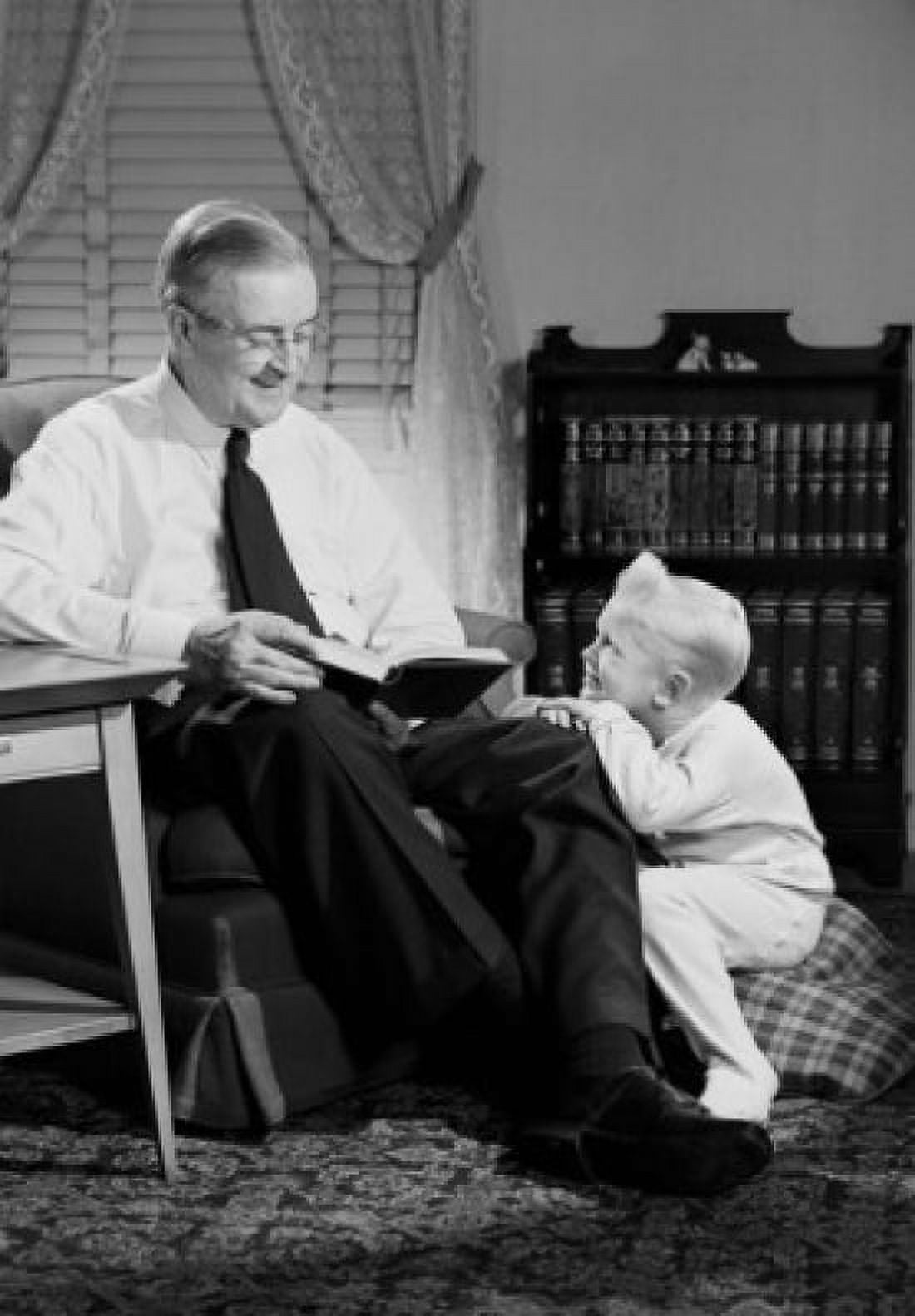 Grandfather reading to grandson in living room Canvas Art - (24 x 36)