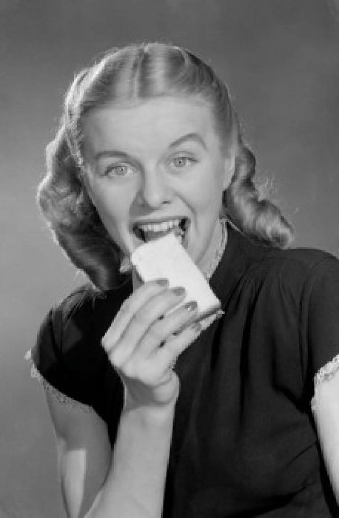 Greedy young woman eating biscuit Canvas Art - (24 x 36)