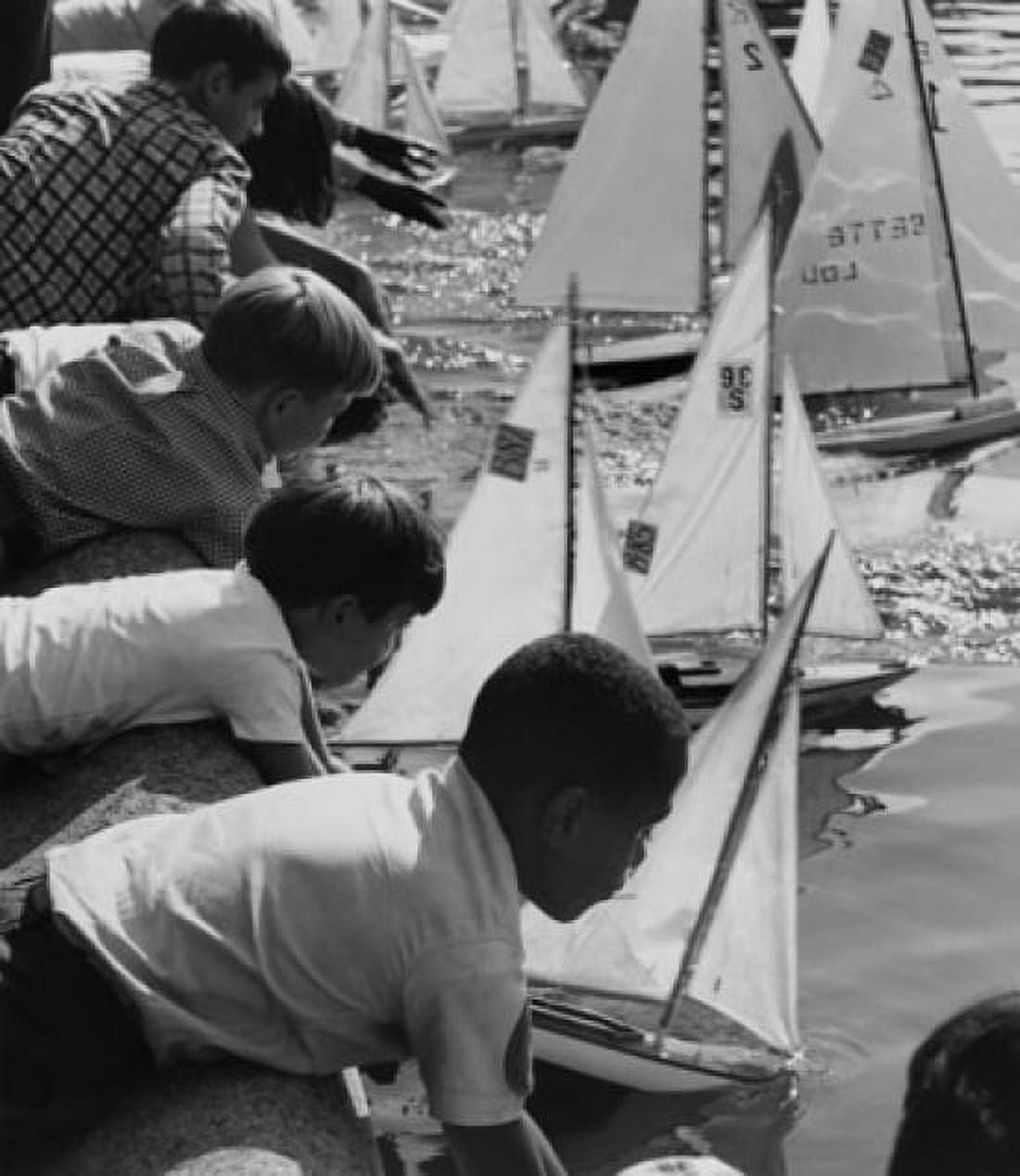 Group of children placing their toy boats in water for a race Canvas Art - (24 x 36)