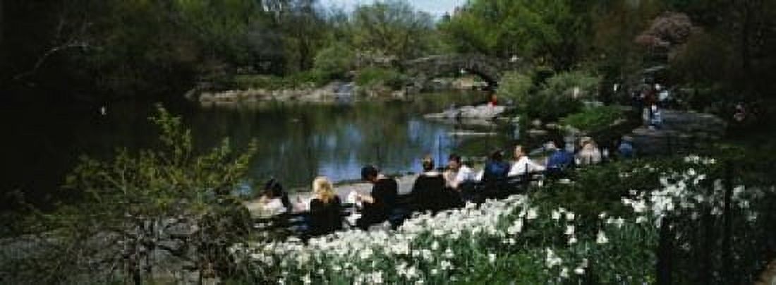 Group of people sitting on benches near a pond Central Park Manhattan New York City New York State USA Canvas Art - Panoramic Images (18 x 7)