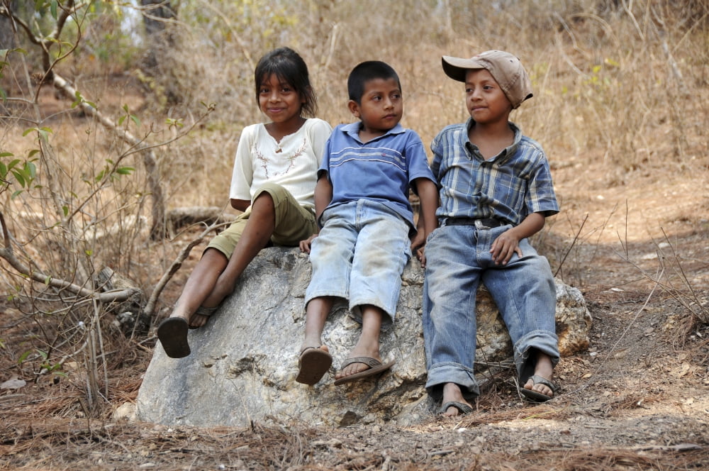Guatemalan children sitting on a rock in El Robles Guatemala Canvas Art - Stocktrek Images (34 x 23)