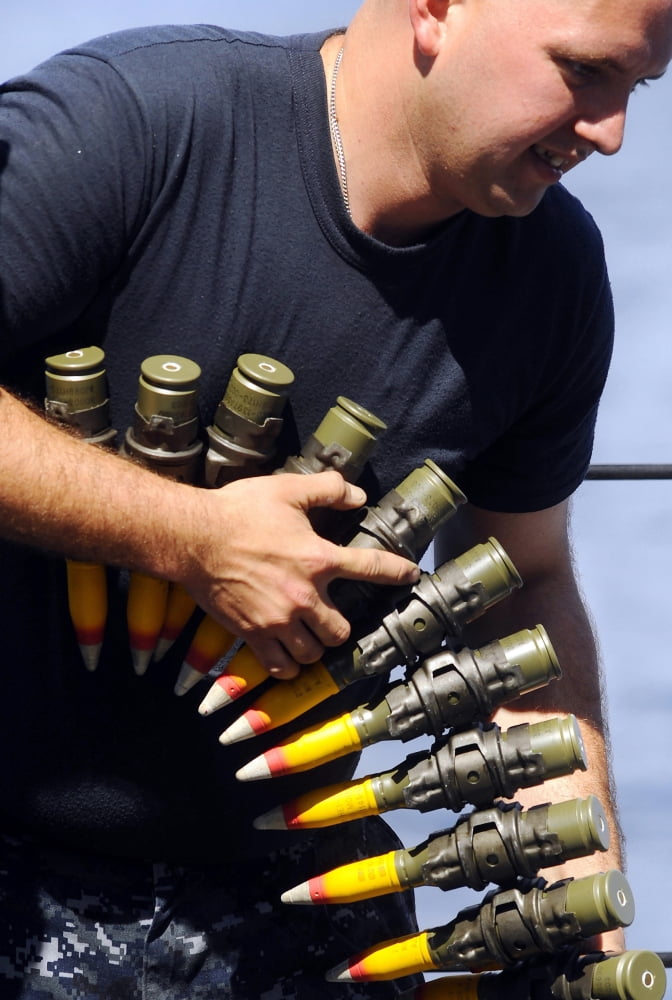 Gunners Mate downloading an ammo belt from an MK 38 25mm gun on USS Fort McHenry Canvas Art - Stocktrek Images (23 x 34)