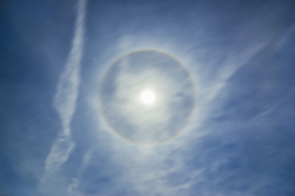 Halo around full moon in a sky of cirrus clouds and contrails Canvas Art - Alan DyerStocktrek Images (17 x 12)