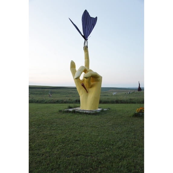 Hand with finger extended holds a butterfly but there is a stake in the palm Poster Print (18 x 24)