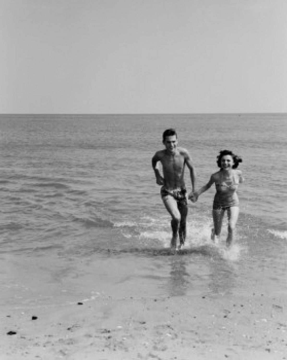 Happy young couple on beach holding hands Canvas Art - (18 x 24)