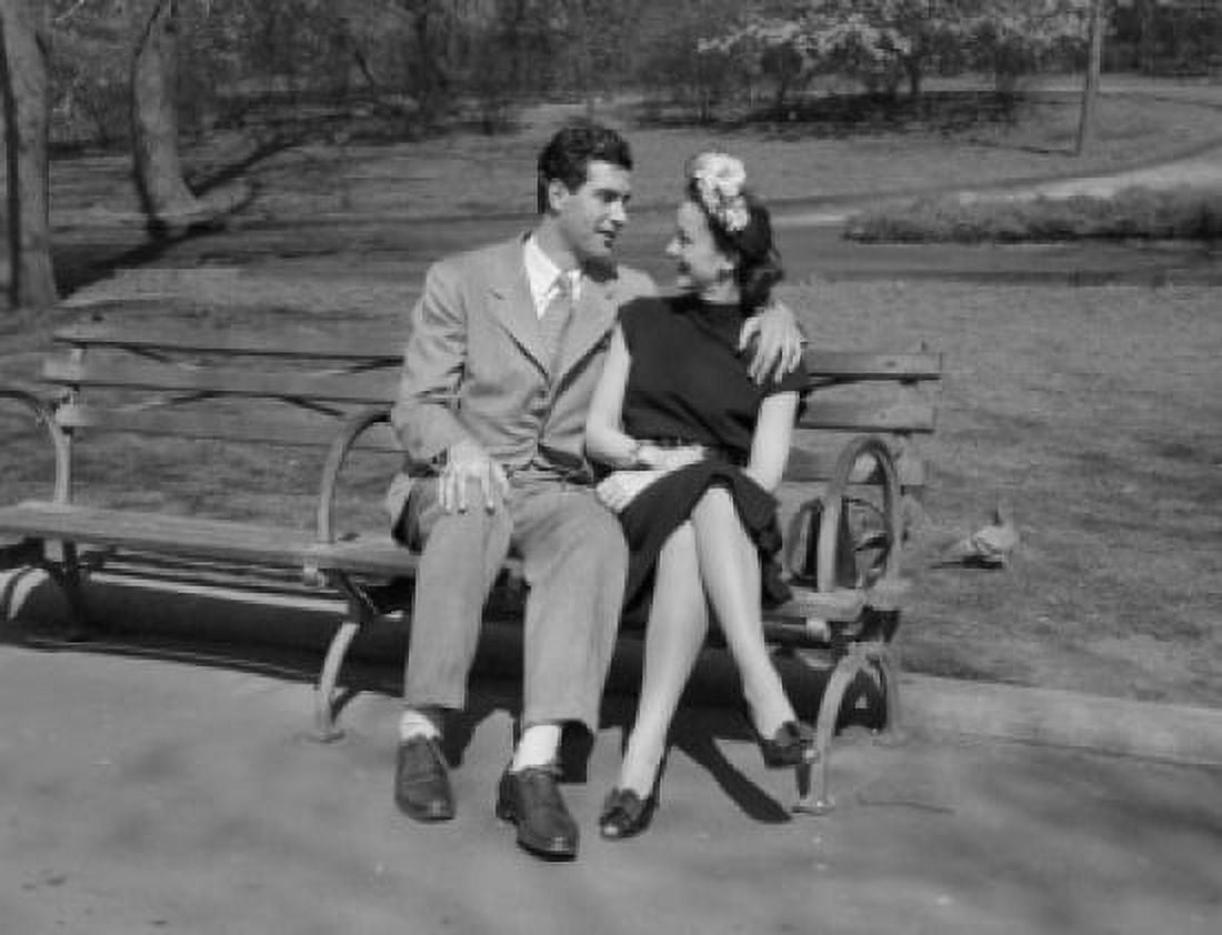 Happy young couple sitting on bench in park Canvas Art - (24 x 36)