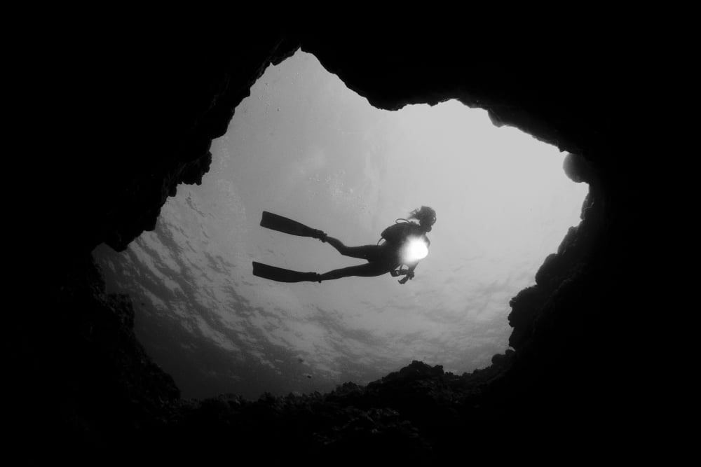 Hawaii Big Island Kona Diver With Flashlight Framed By Cavern Entrance (Black And White Photograph) Canvas Art - Dave Fleetham Design Pics (36 x 24)
