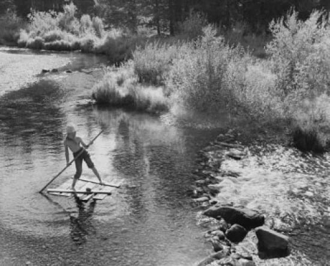 High angle view of a boy standing on a wooden raft Canvas Art - (18 x 24)