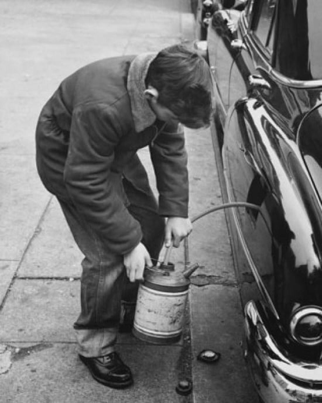 High angle view of a boy stealing gasoline from a car Canvas Art - (18 x 24)