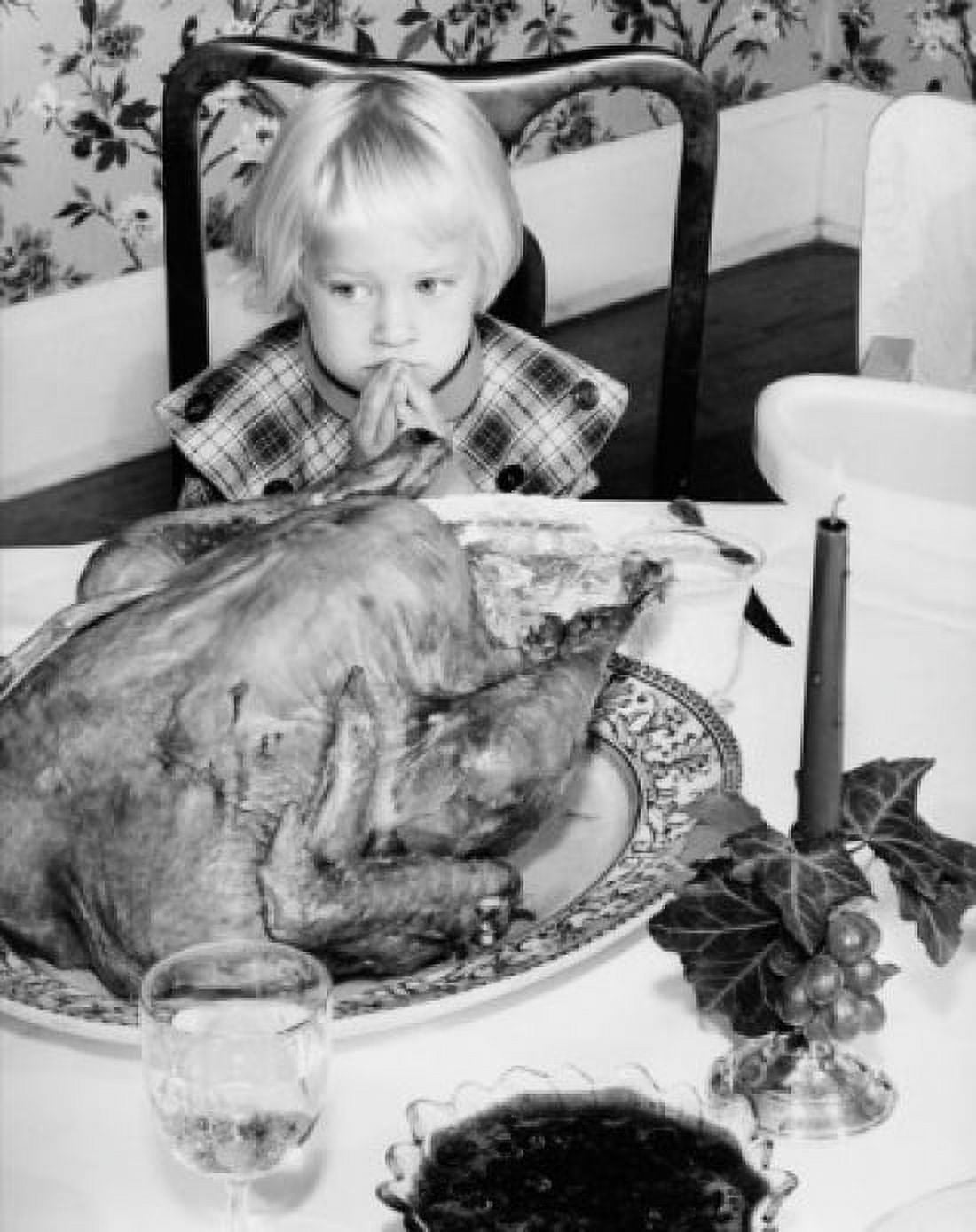 High angle view of a girl sitting at a dining table and looking at a roast turkey on Thanksgiving Day Canvas Art - (18 x 24)