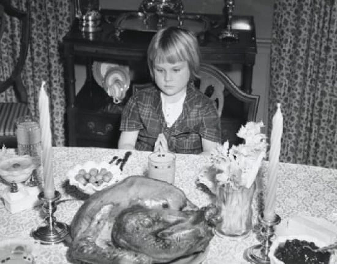 High angle view of a girl sitting at a dining table and looking at a roasted turkey on Thanksgiving Day Canvas Art - (24 x 36)