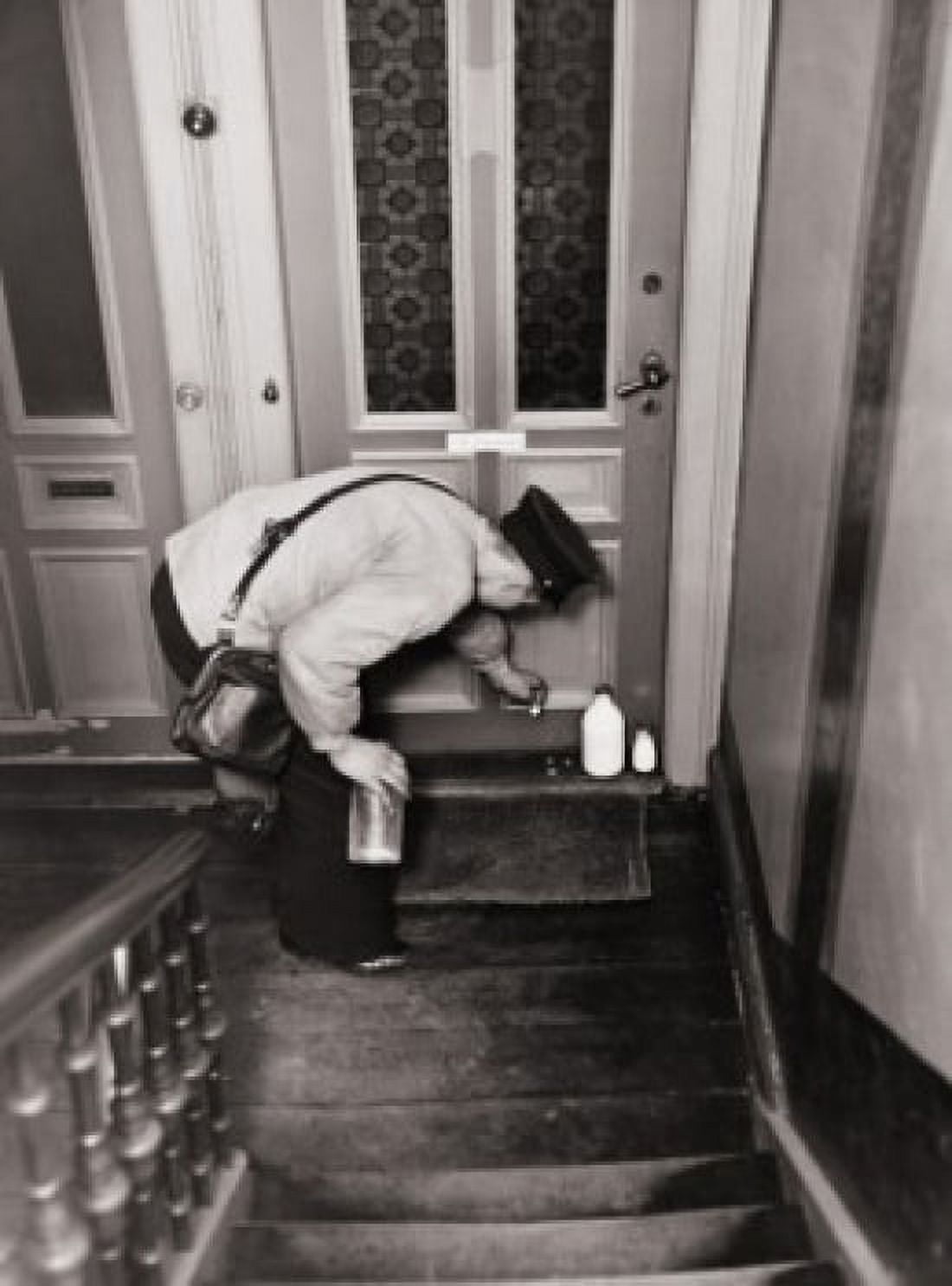 High angle view of a mid adult delivering milk bottle at doorstep Canvas Art - (18 x 24)