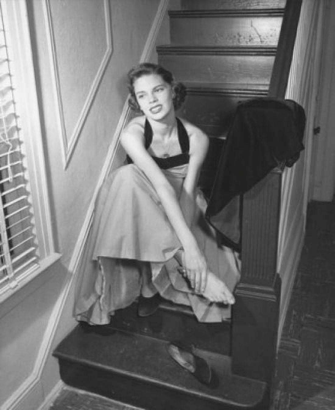 High angle view of a young woman sitting on a staircase holding her ankle Canvas Art - (18 x 24)