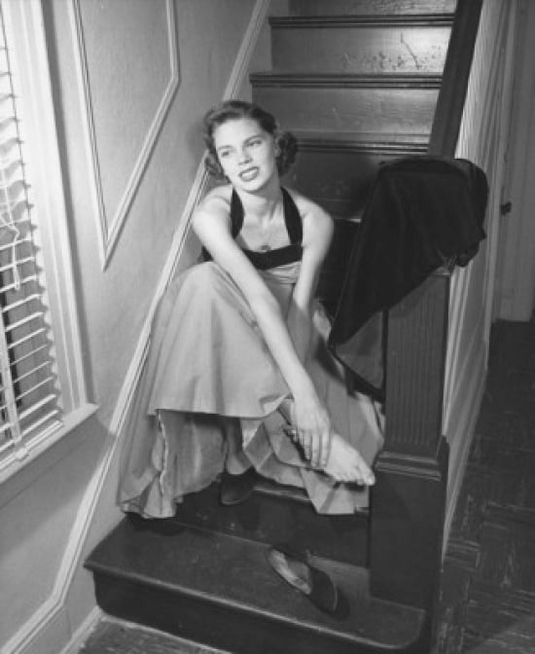 High angle view of a young woman sitting on a staircase holding her ankle Canvas Art - (24 x 36)