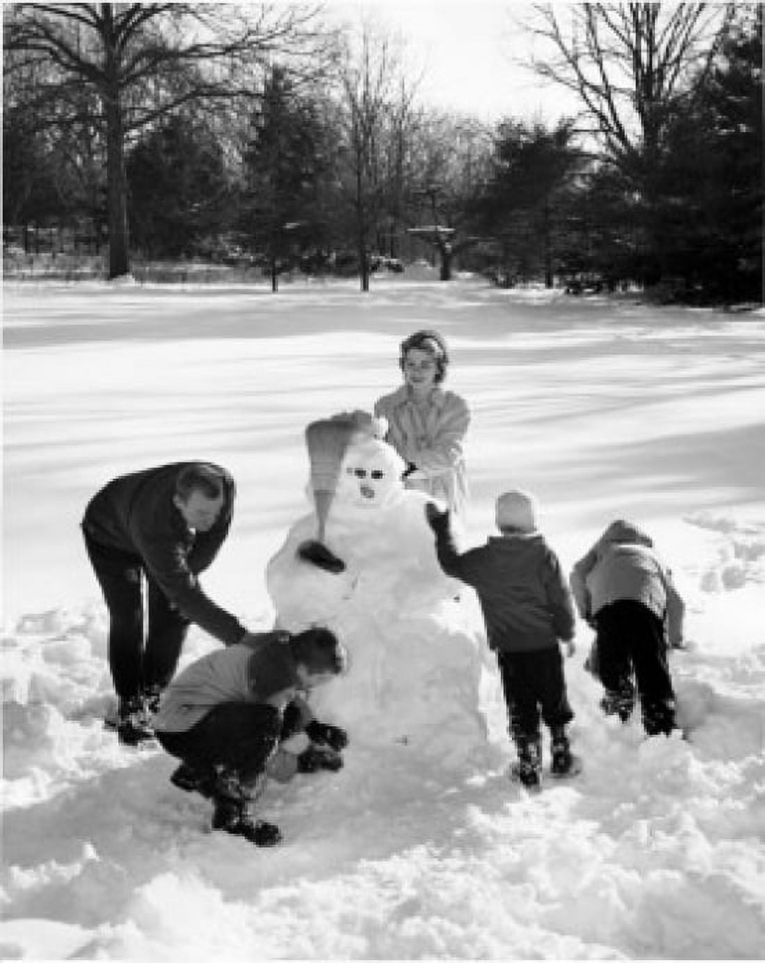 High angle view of parents and their three children making a snowman Canvas Art - (18 x 24)