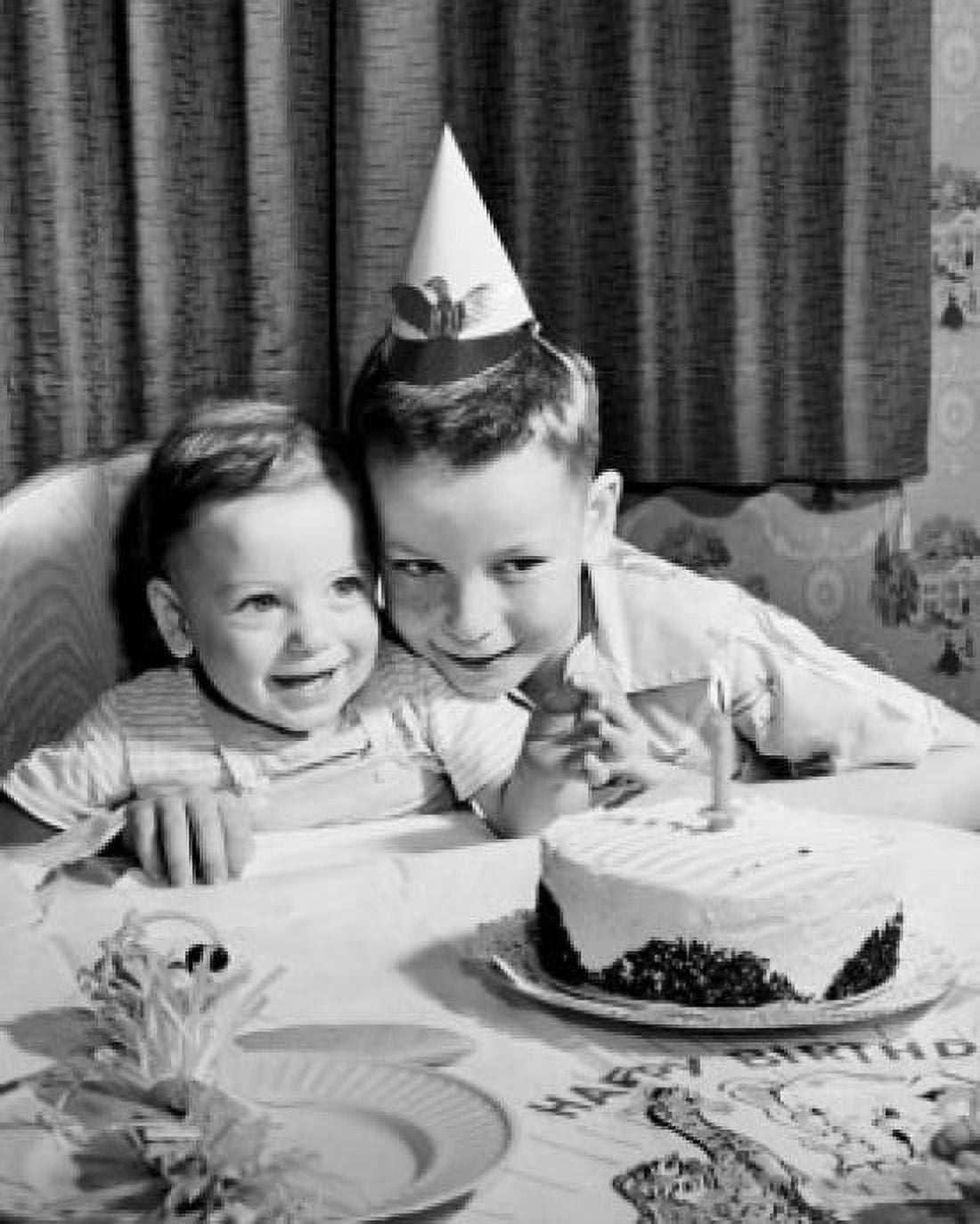 High angle view of two boys sitting in front of a birthday cake and smiling Canvas Art - (18 x 24)