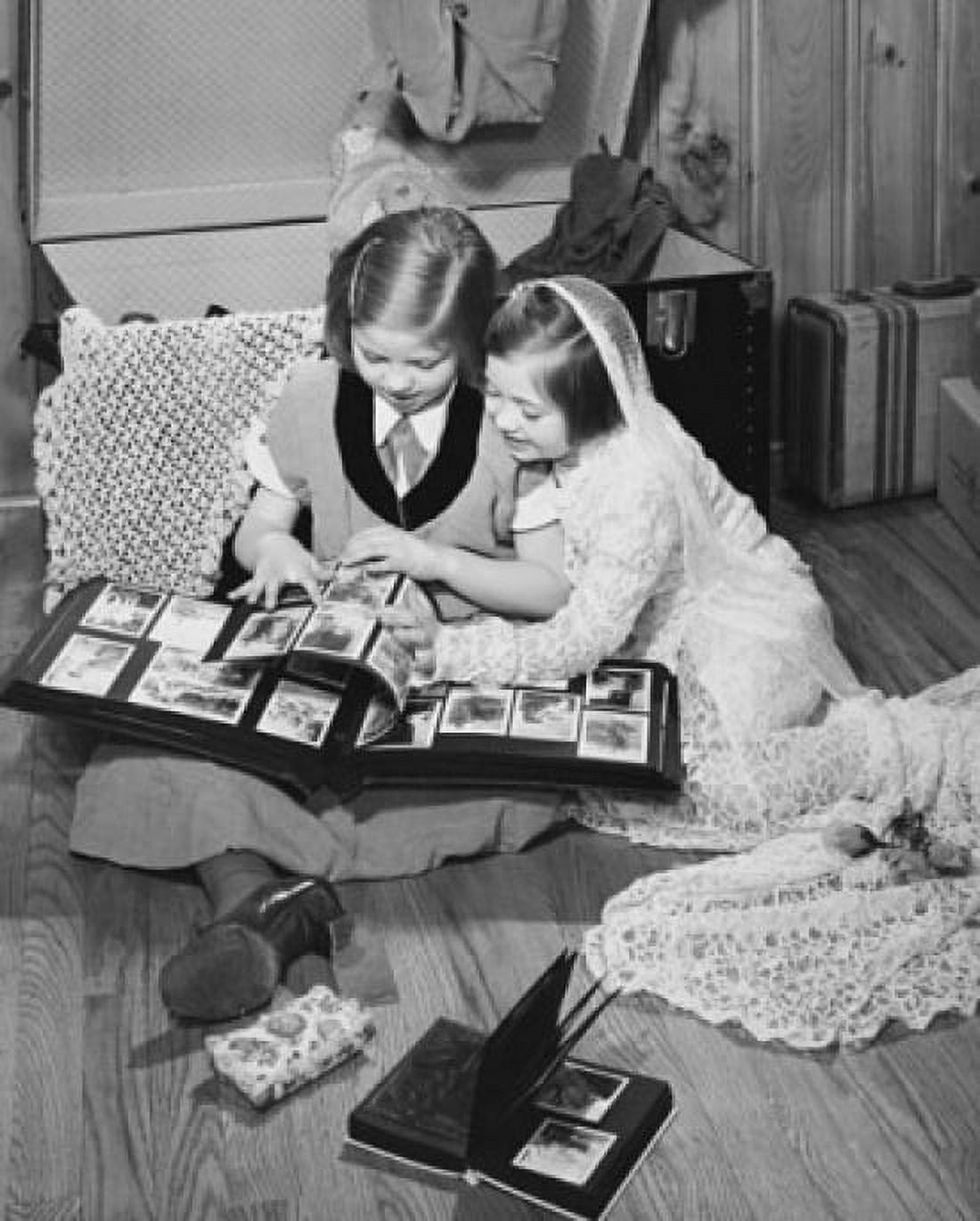 High angle view of two girls looking at a photo album Canvas Art - (24 x 36)