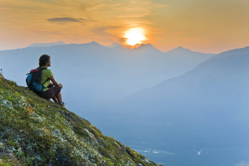 Hiker Sits On Steep Hillside Of Mt Alyeska Watching The Sun Set Over Girdwood Valley In Southcentral Alaska Canvas Art - Michael DeYoung Design Pics (17 x 11)