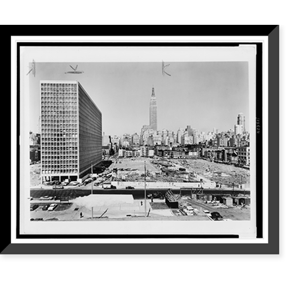 Historic Framed Print, [Kip's Bay Suite construction project, showing finished building exterior and foundations for additional buildings, New York City in background], 17-7/8" x 21-7/8"