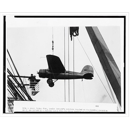 Historic Print, Amelia Earhart's airplane dangling at the loading operation, as it was lifted by a derrick barge from the liner Lurline at Honolulu.Pan Pacific Press photo., 16" x 20"