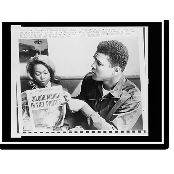 Historic Print, Cassius Clay points to newspaper headline to prove that he's not the only one protesting the Viet Nam war, 16" x 20"