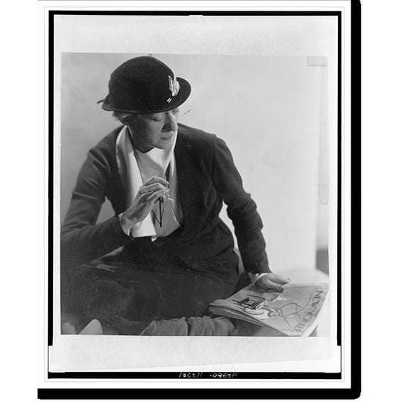 Historic Print, [Janet Flanner, three-quarter length portrait, seated, looking at an issue of The New Yorker magazine], 16" x 20"