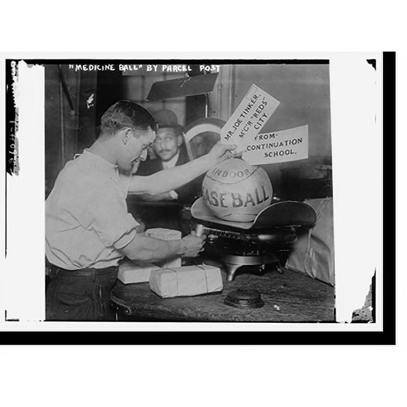 Historic Print, Medicine ball being weighed by Post Office employee; shipping tags read: Mr. Joe Tinker, Mgr Reds (Cincinnati) From Continuation School. 1913, 16" x 20"