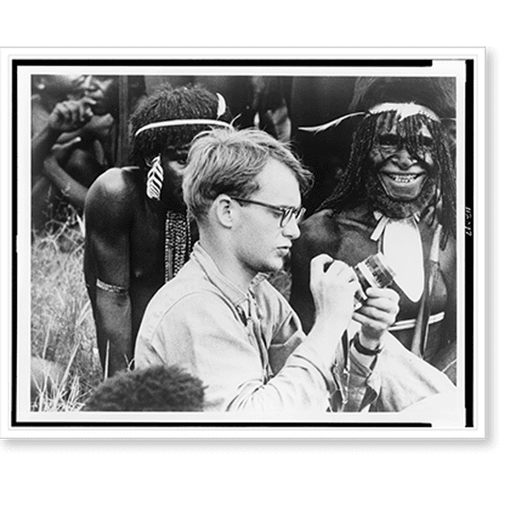 Historic Print, [Michael C. Rockefeller adjusting his camera in New Guinea, Papuan men in background], 18" x 24"