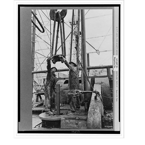 Historic Print, Oil field workers, reaching for clamp on elevator. The elevator removes the pipe from the drill hole, Kilgore, Texas, 16" x 20"