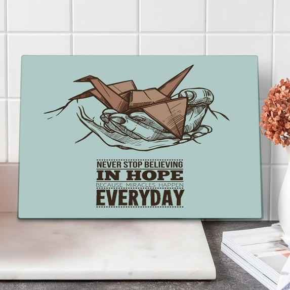Hope Cutting Board, Hands Holding an Origami Crane with a Miracles Happen Everyday Words, Decorative Tempered Glass Cutting and Serving Board, Large Size, Pale Orange Brown White, by Ambesonne