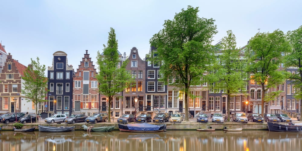 Houses and boats along the Herengracht canal Amsterdam North Holland Netherlands Canvas Art - Panoramic Images (9 x 27)