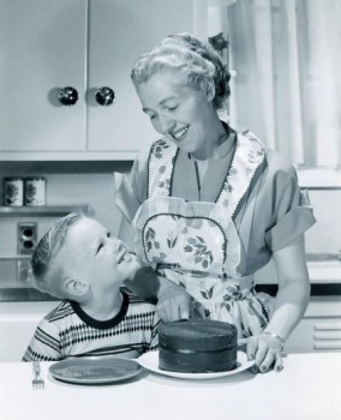 Housewife with toddler standing in kitchen with cake in foreground Canvas Art - (18 x 24)