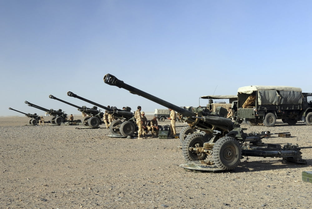 Howitzer 105mm light guns are lined up at Camp Bastion Afghanistan Canvas Art - Andrew ChittockStocktrek Images (34 x 23)