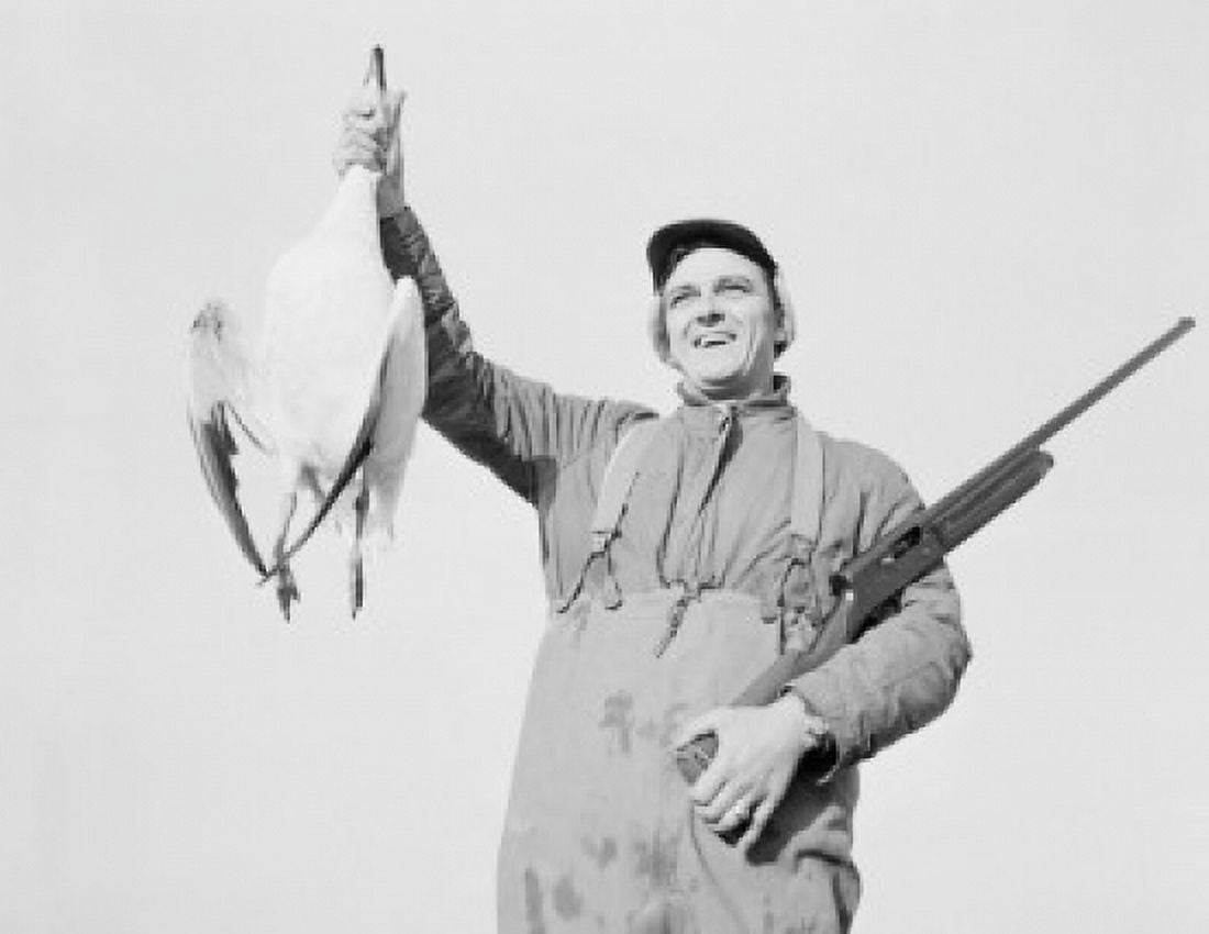 Hunter holding dead snow goose Canvas Art - (18 x 24)