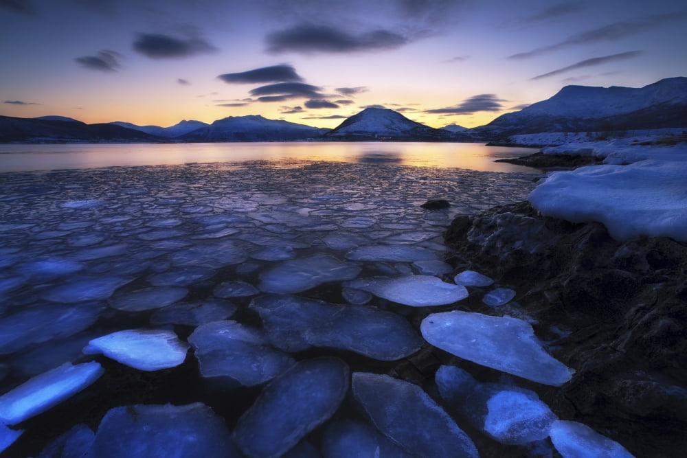 Ice flakes drifting against the sunset in Tjeldsundet strait Troms County Norway Canvas Art - Arild HeitmannStocktrek Images (35 x 23)