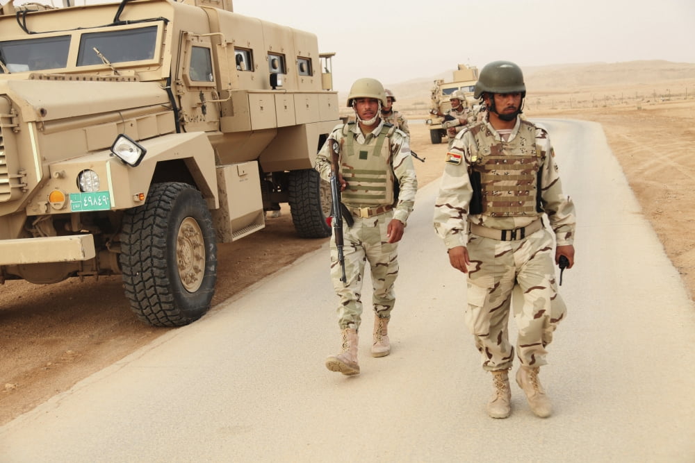 Iraqi army soldiers walk beside an MRAP vehicle in Iraq Canvas Art - Stocktrek Images (35 x 23)