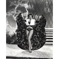 thumbnail image 1 of Jane Russell Posed in White V-Neck Sleeveless Top and Black Long Skirt while Hands Raised and Holding the Skirt Up to the side Photo Print (24 x 30), 1 of 1