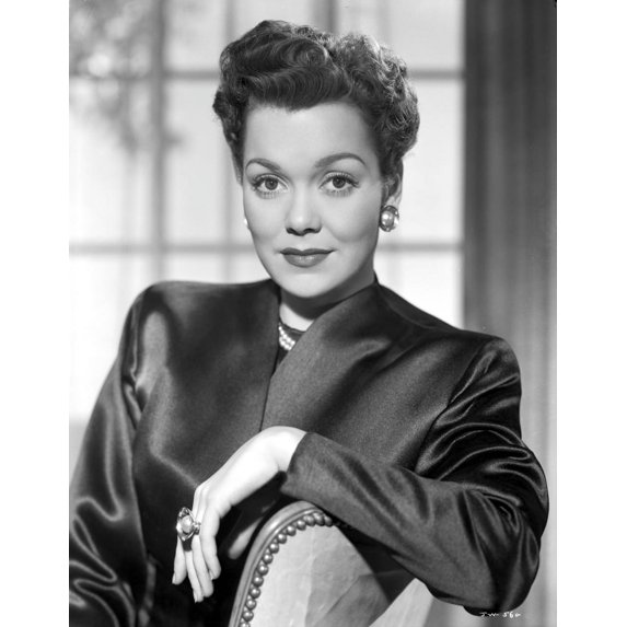 Jane Wyman sitting on the Chair in Black Velvet Long Sleeve Blazer and Pearl Earrings with Right Hand on the Top Railing Photo Print (8 x 10)