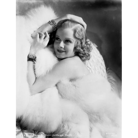 Jean Harlow Posed and sitting on a White Couch in White Fur Pelt Shoulder Dress and Fur Coat with Hands Together Photo Print (8 x 10)