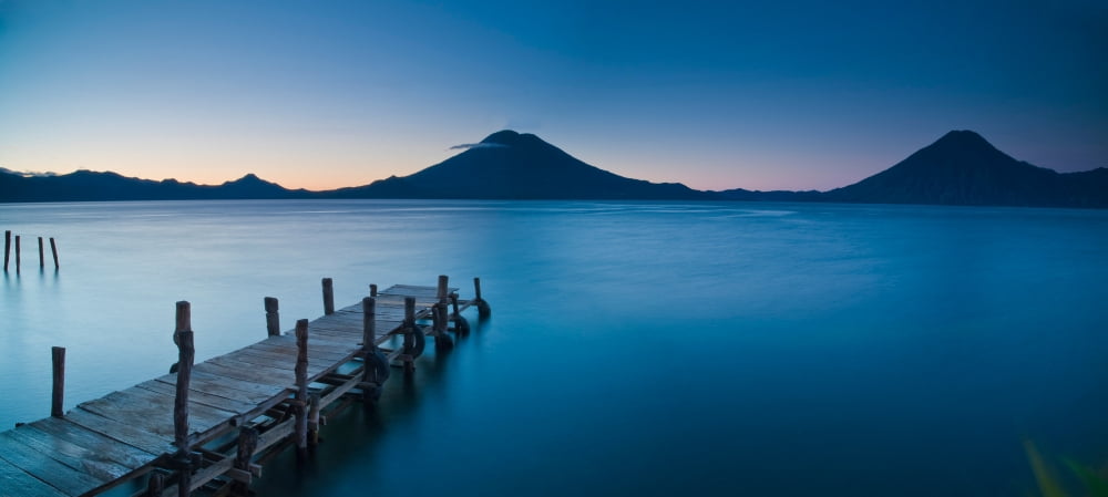 Jetty in a lake with a mountain range in the background Lake Atitlan Santa Cruz La Laguna Western Highlands Guatemala Canvas Art - Panoramic Images (12 x 27)