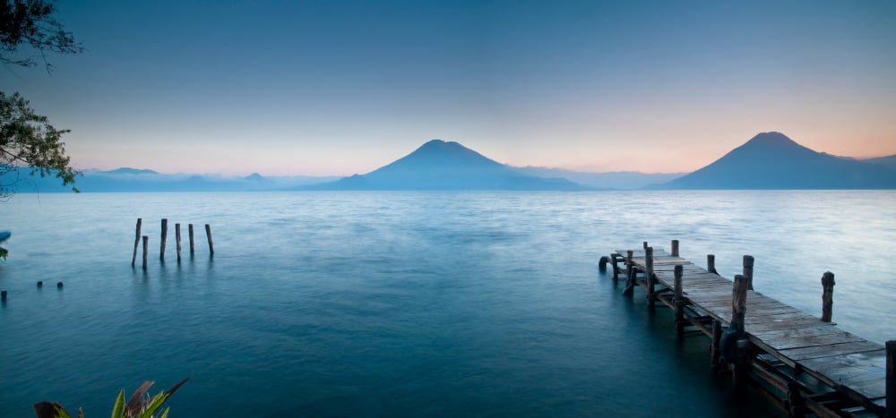 Jetty in a lake with a mountain range in the background Lake Atitlan Santa Cruz La Laguna Western Highlands Guatemala Canvas Art - Panoramic Images (27 x 9)