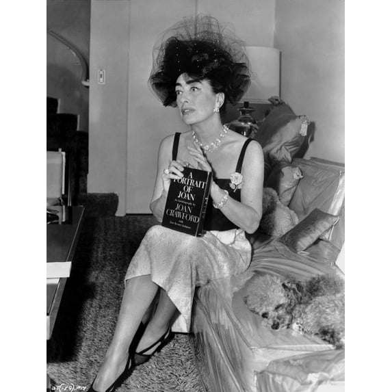 Joan Crawford sitting on the Sofa and Holding a Book in Classic Photo Print (24 x 30)
