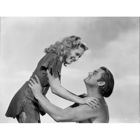 Johnny Weissmuller Lifting a Lady with His Two Hands in a Movie Scene Photo Print (24 x 30)