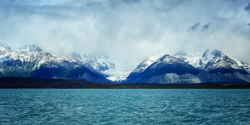 Lake with snow capped mountains in background Lago Argentino Santa Cruz Province Patagonia Argentina Canvas Art - Panoramic Images (12 x 24)